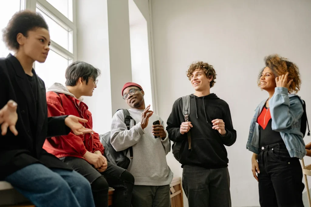 Older students chatting near a window